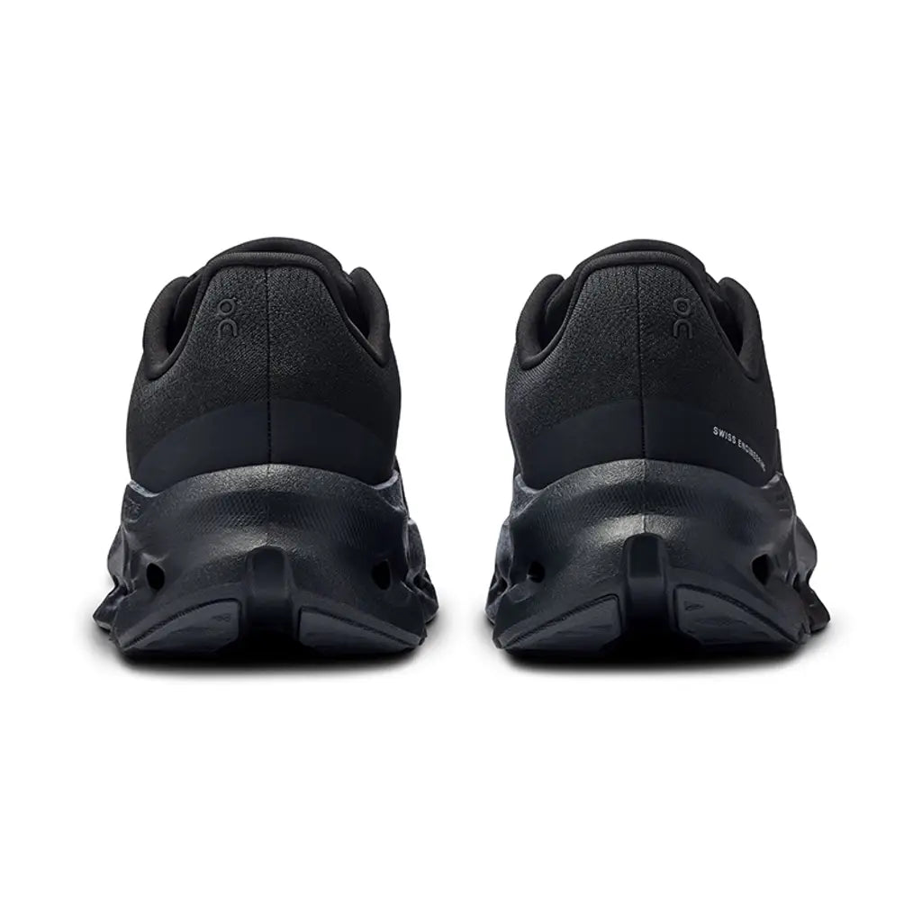 Black athletic shoes shown from the back on a white background